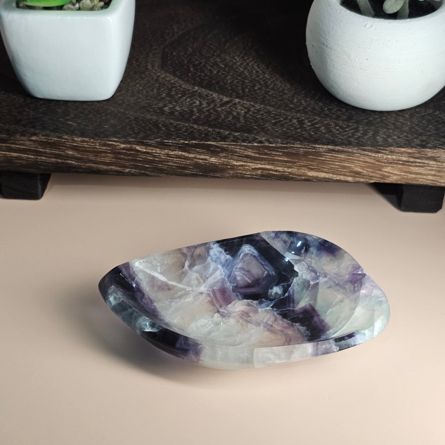 Front-facing view of the Rainbow Fluorite dish on a surface, showcasing its polished finish and natural zoning of white, purple, blue, and green.
