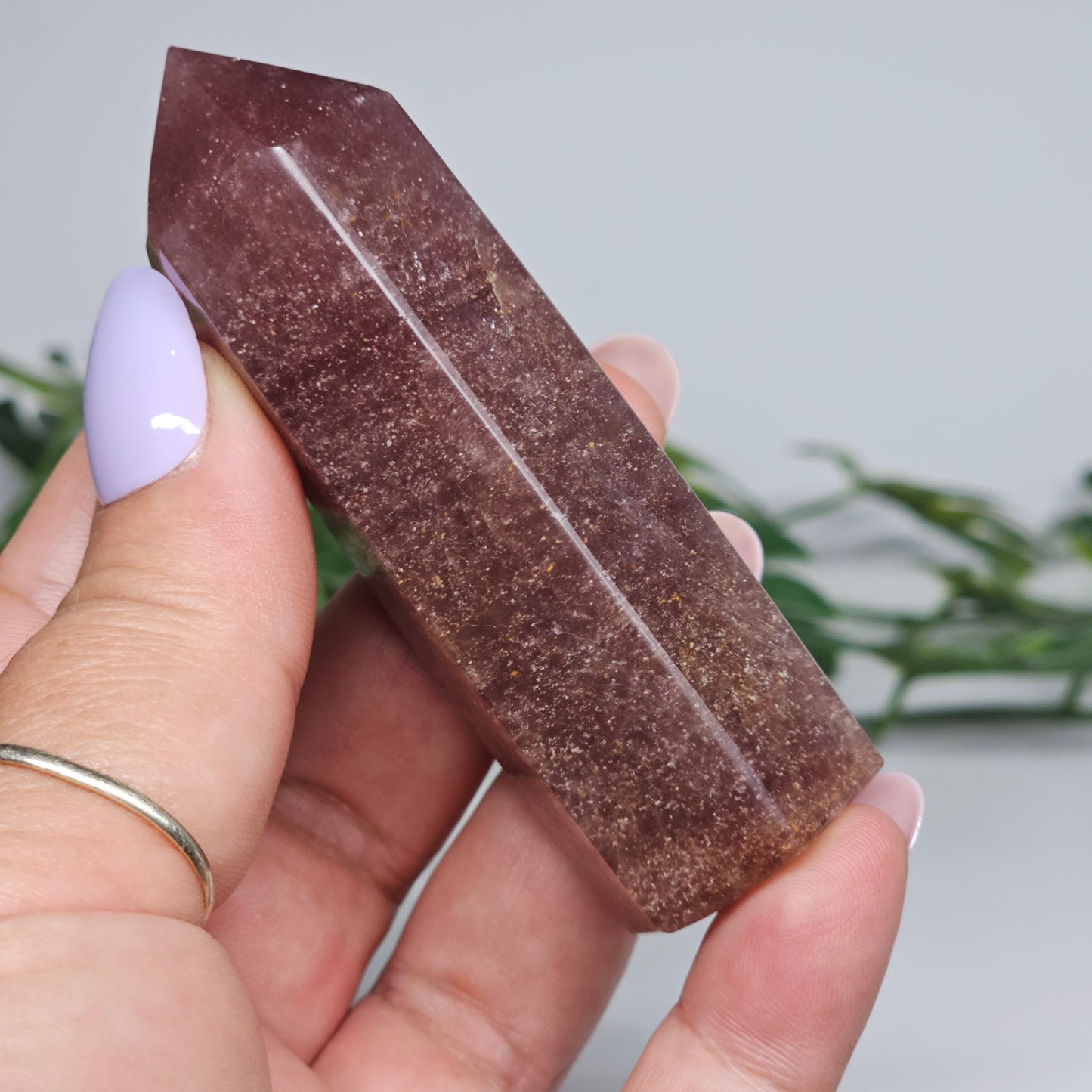 Red Aventurine tower crystal held in hand showing size and natural colour depth