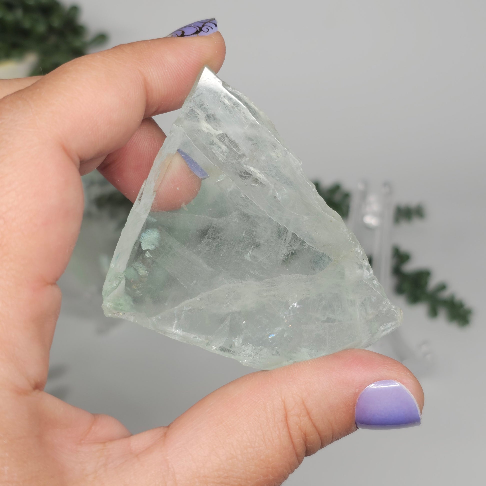 Small Green Fluorite slab shown from the reverse side in hand, revealing internal structure and natural clarity.