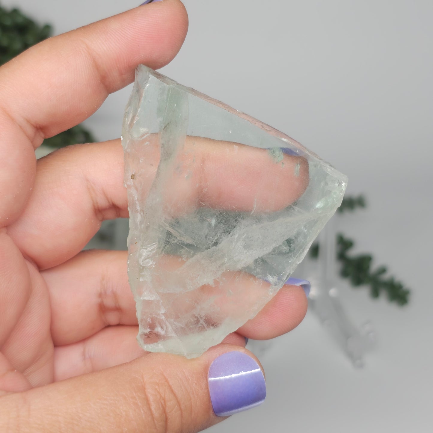 Small Green Fluorite slab held in hand, highlighting its soft green tones and high transparency.