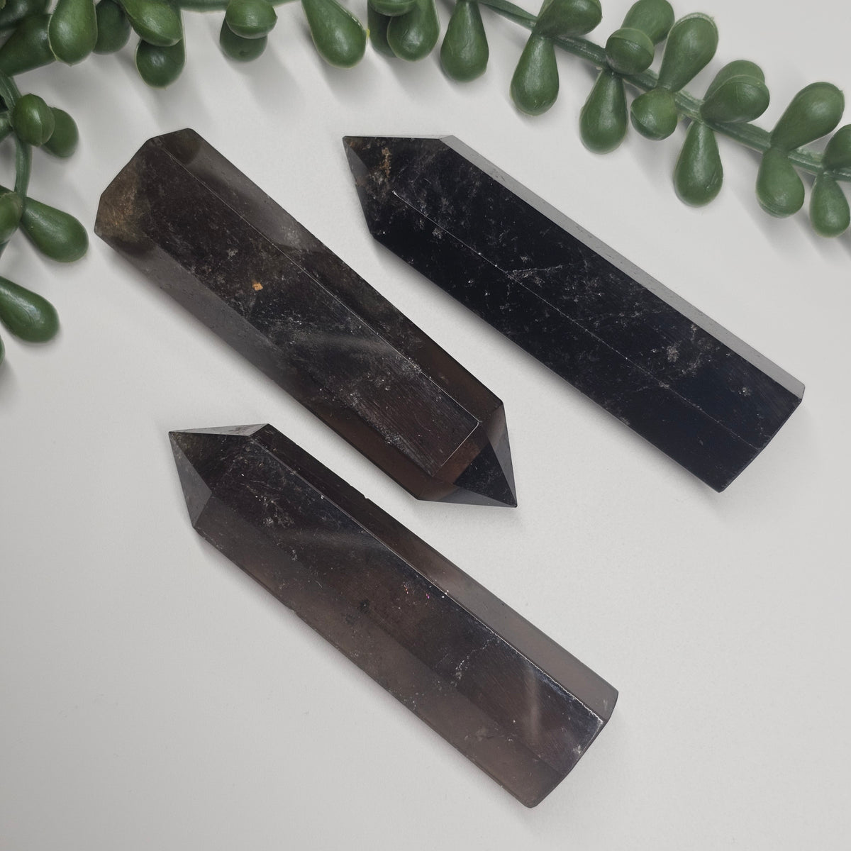 Translucent and Opaque Smoky Quartz towers laid flat on a white surface