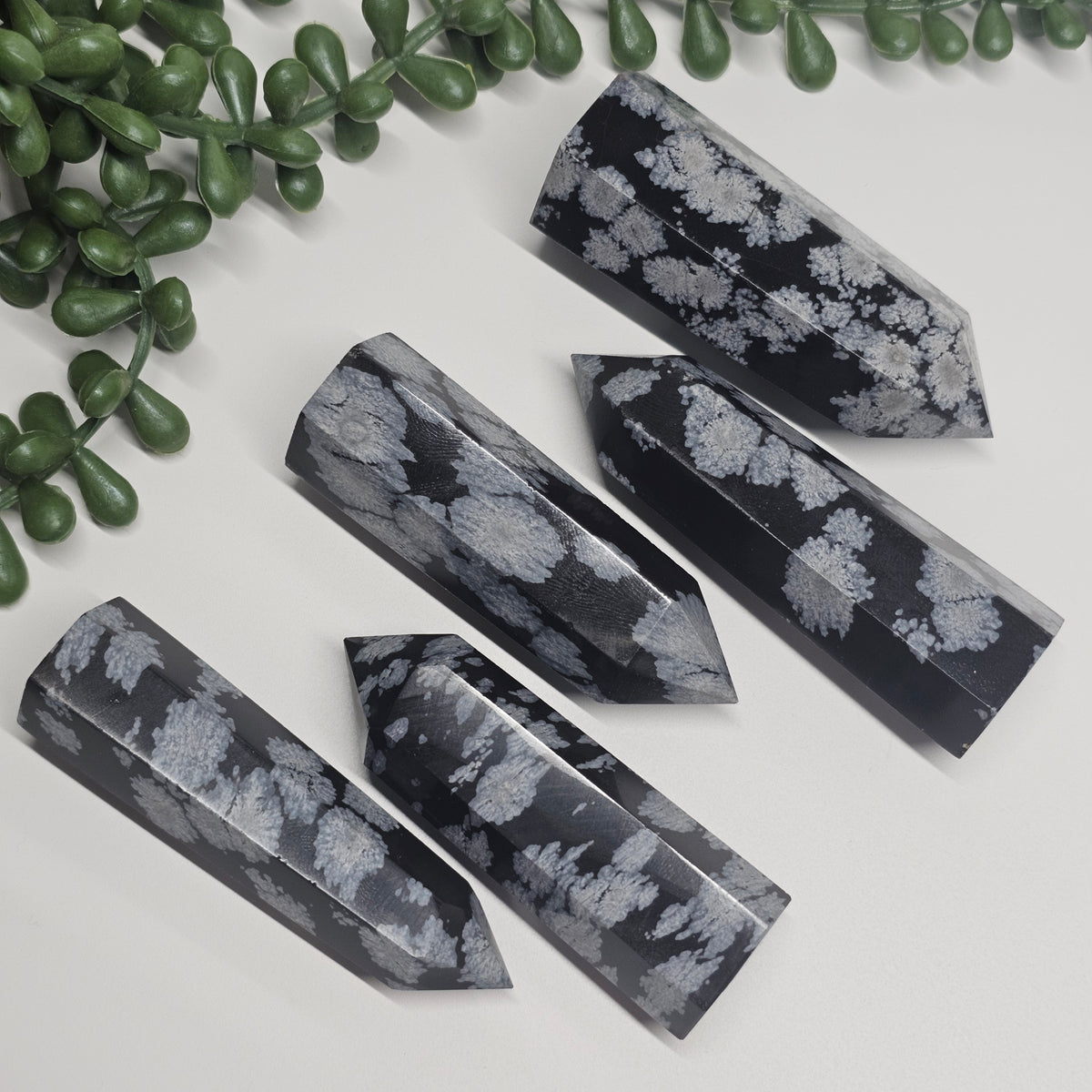 Snowflake Obsidian towers laid flat on a white surface 