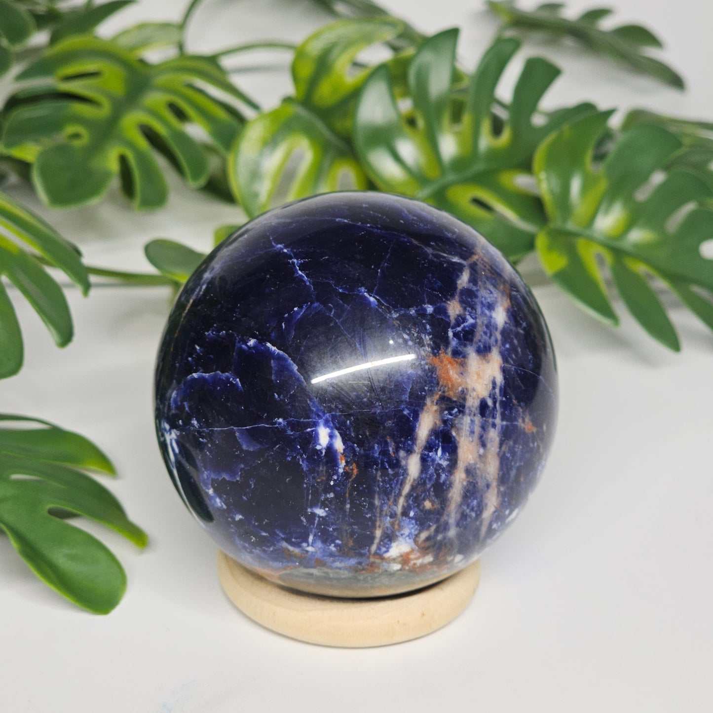 Sodalite sphere A displayed on its stand, showing the front-facing pattern of rich blue and natural white veining.