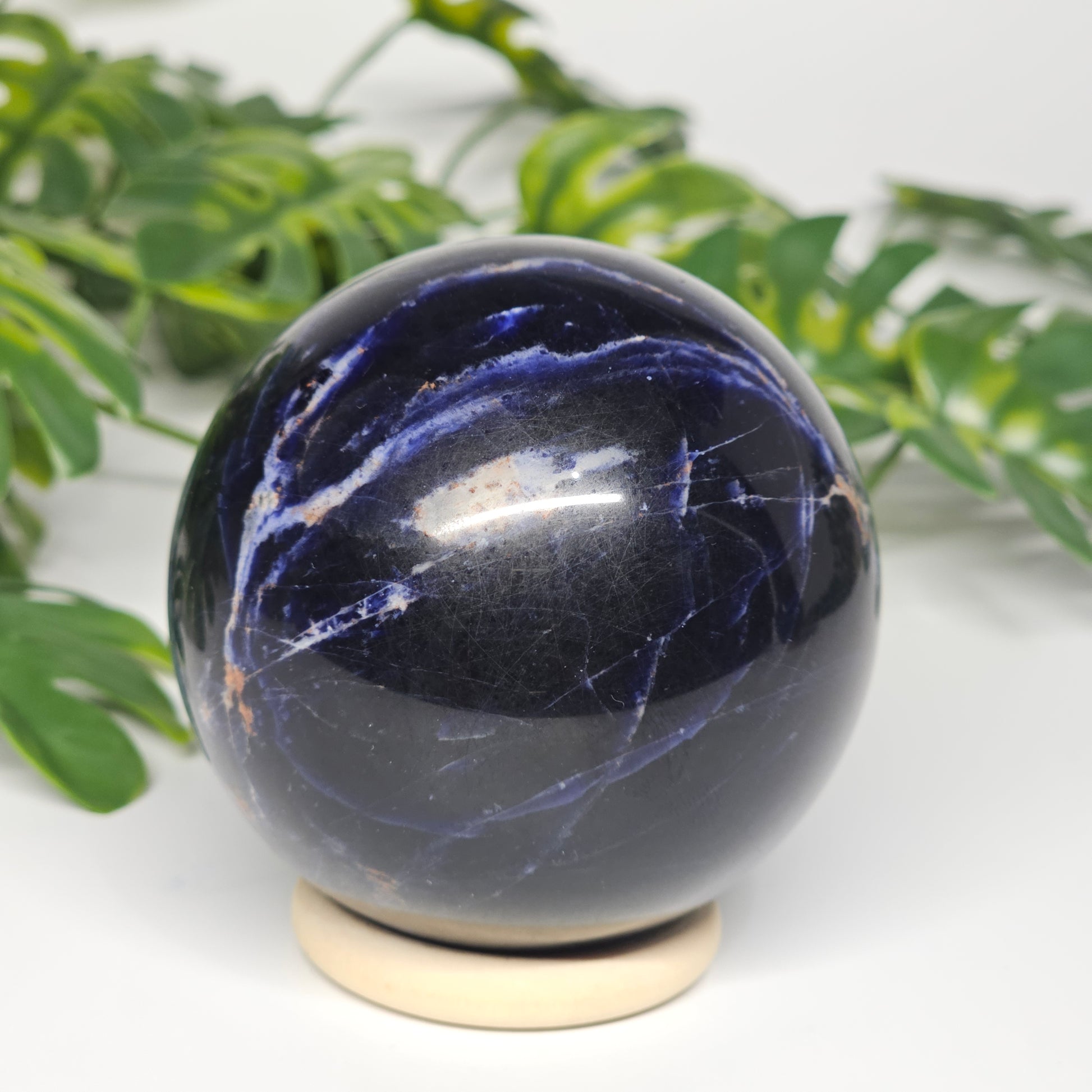 Rotational view of Sodalite sphere B on stand, highlighting its deep colouring, subtle grey inclusions, and polished surface.