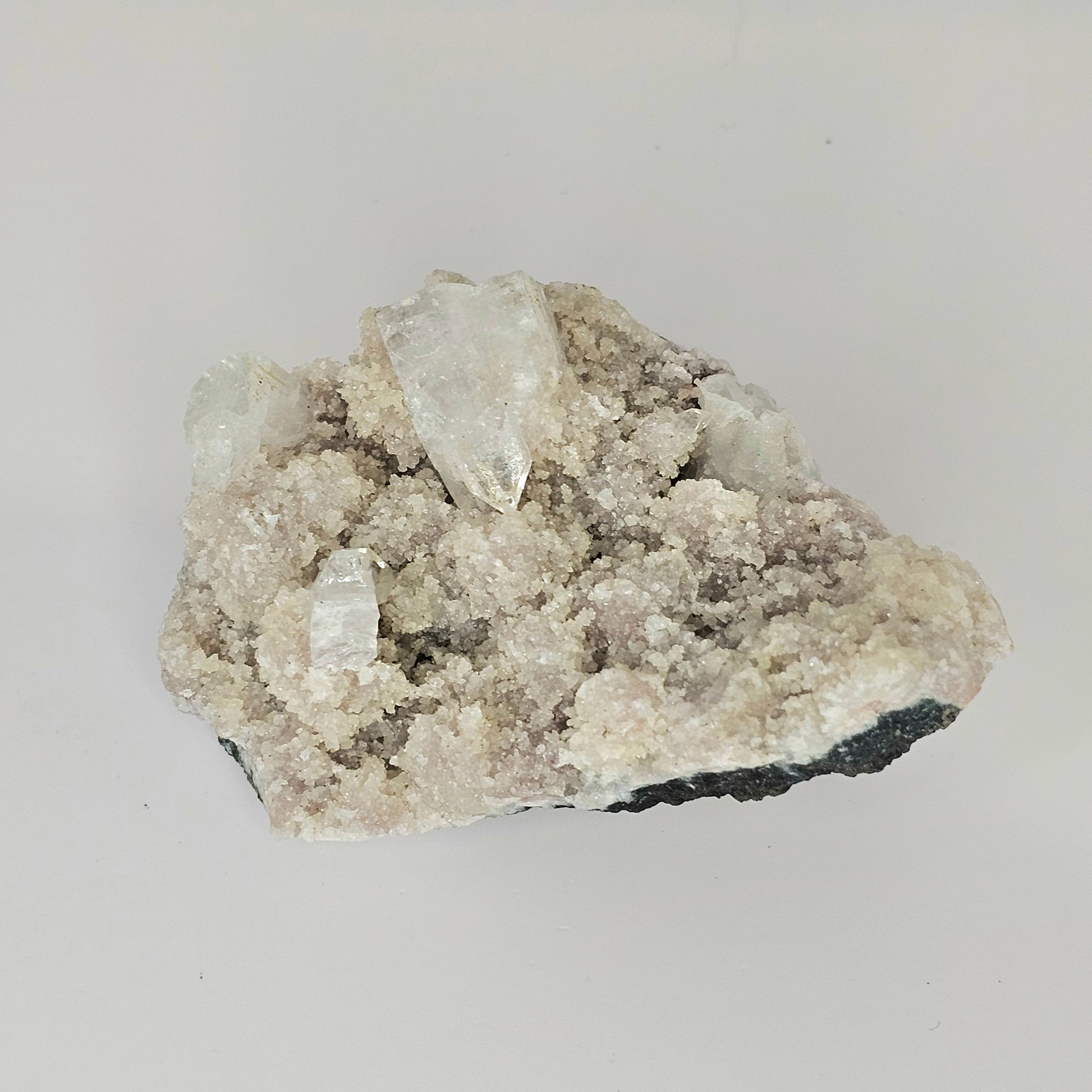 Close-up angle of the Mauve Apophyllite specimen highlighting its glittering sugary crystal texture and natural light-reflective surfaces.