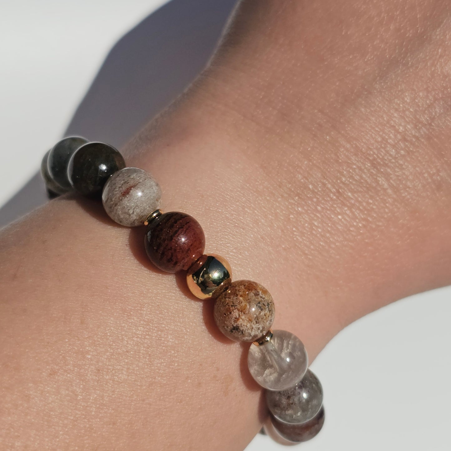10mm Thousand Layer Quartz bracelet with gold stainless steel accents worn on wrist