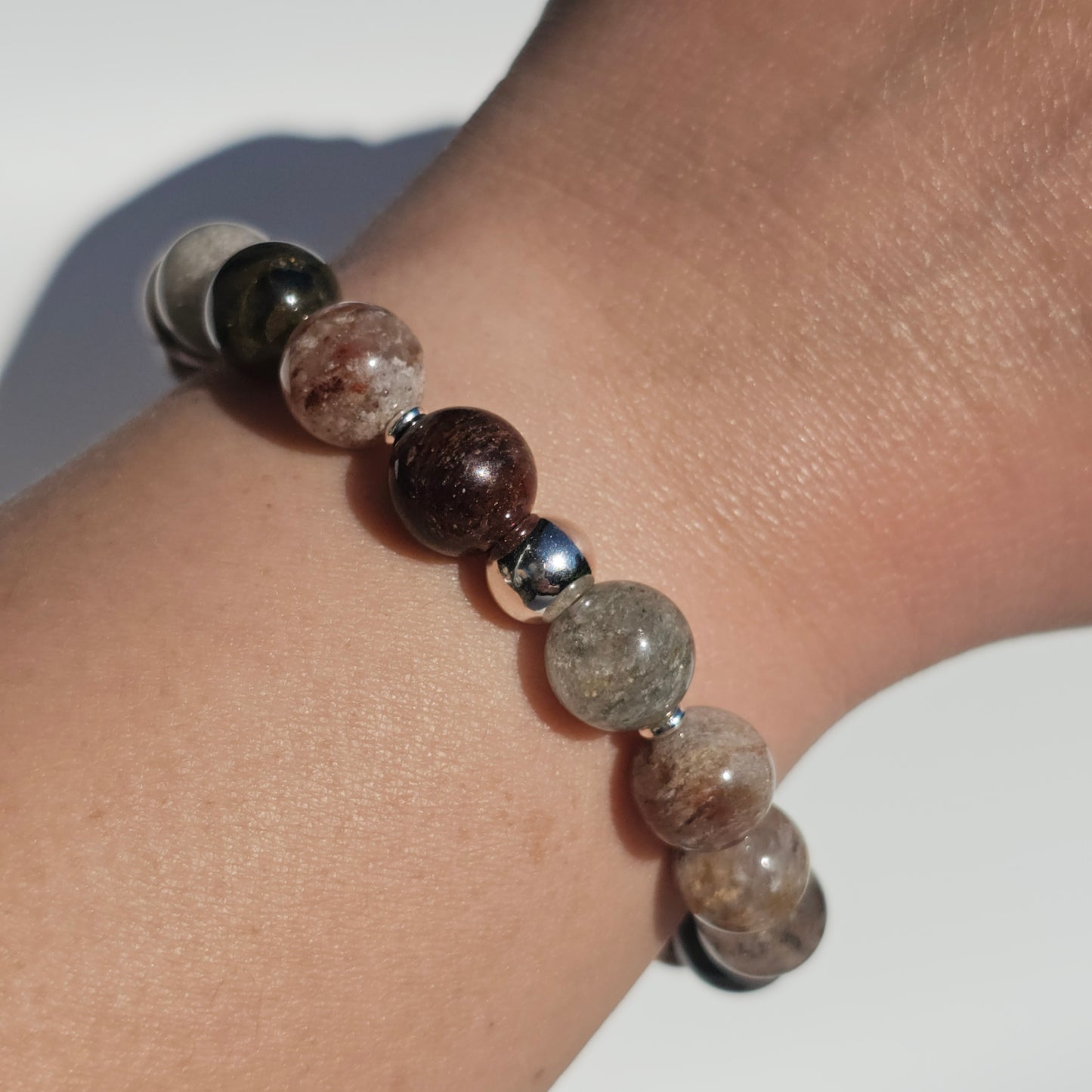 10mm Thousand Layer Quartz bracelet with silver stainless steel accents worn on wrist