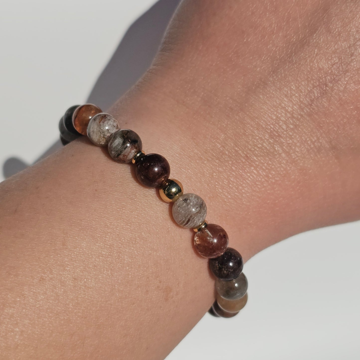 8mm Thousand Layer Quartz bracelet with gold stainless steel accents worn on wrist