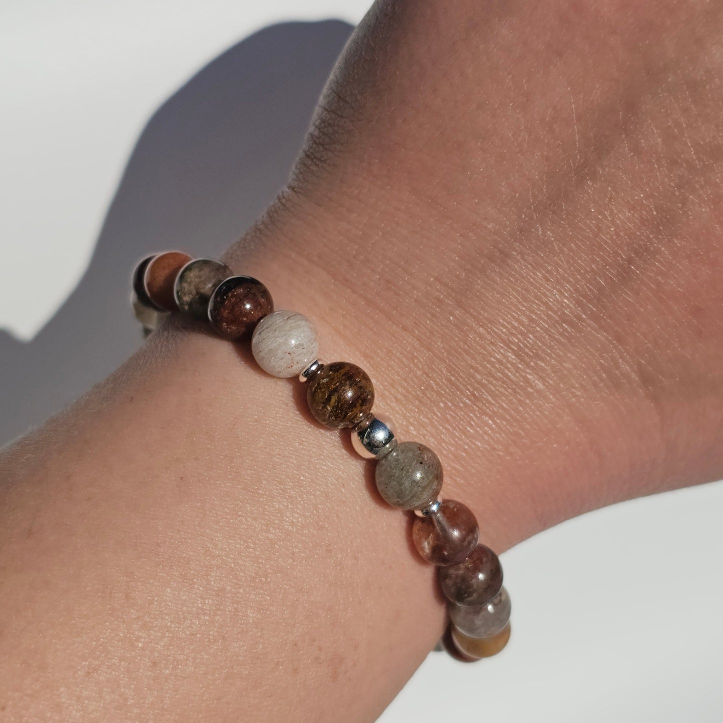 8mm Thousand Layer Quartz bracelet with silver stainless steel accents worn on wrist