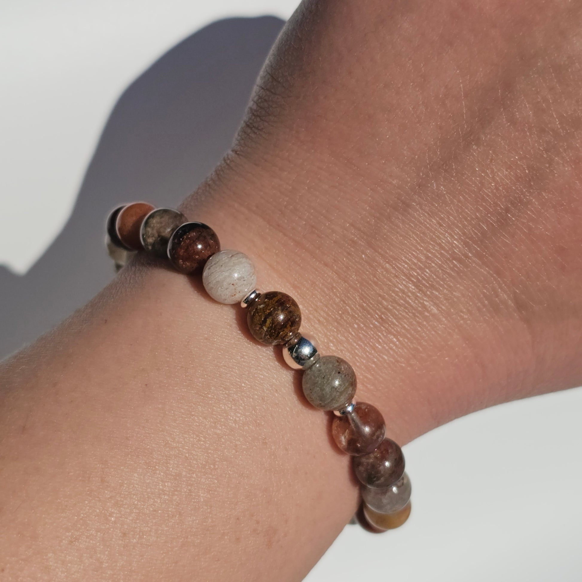 8mm Thousand Layer Quartz bracelet with silver stainless steel accents worn on wrist