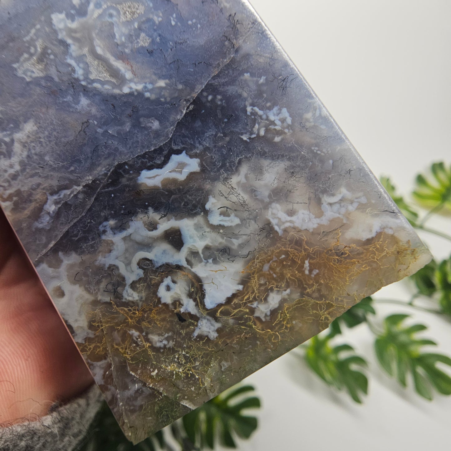 A patch of yellow moss inclusions amongst the dark blue chalcedony crystal tower