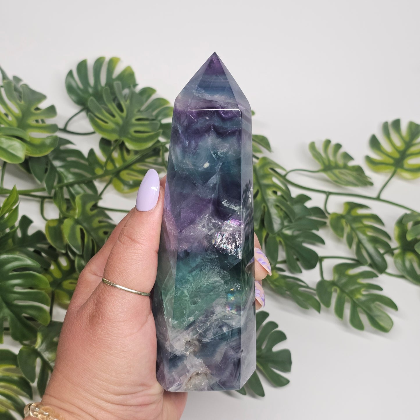 Large fluorite crystal tower held in hand showing size and natural formation