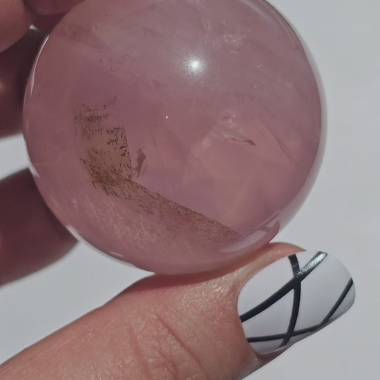 A stunning Rose Quartz sphere with asterism, beautiful rainbows, and gorgeous dendritic inclusions