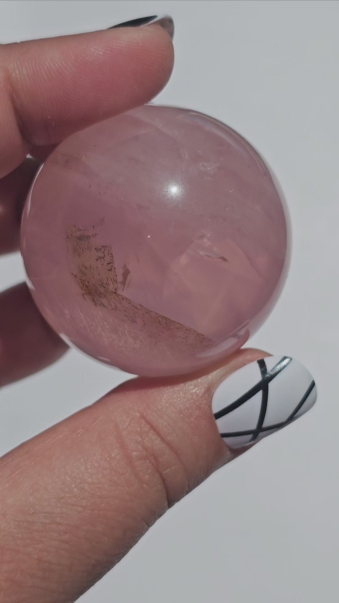 A stunning Rose Quartz sphere with asterism, beautiful rainbows, and gorgeous dendritic inclusions