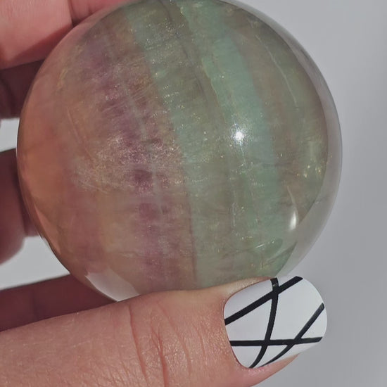 Rainbow Fluorite sphere banded with an array of colours, including a display of beautiful rainbows.