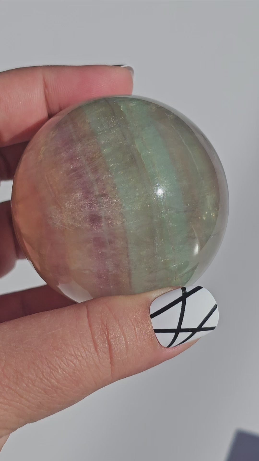 Rainbow Fluorite sphere banded with an array of colours, including a display of beautiful rainbows.