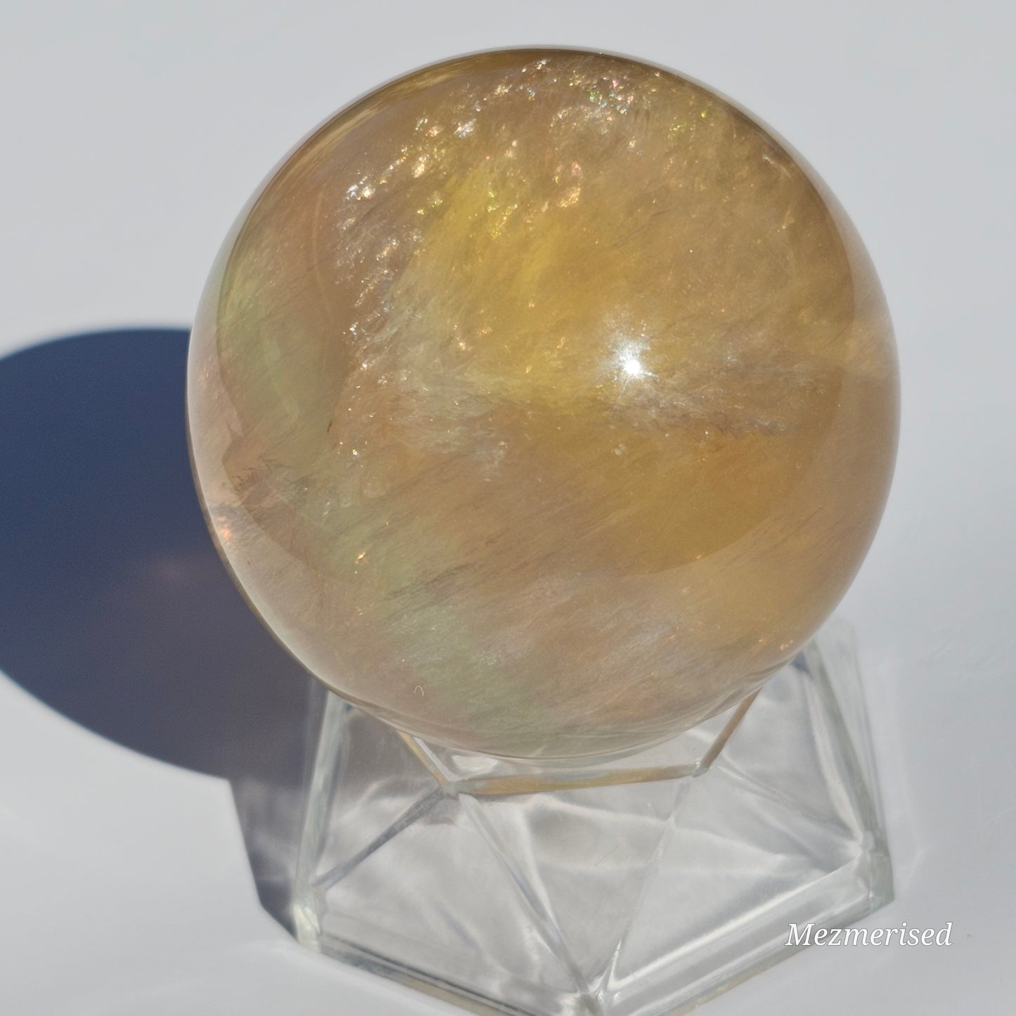 Yellow rainbow Fluorite sphere banded with an array of colours, including a display of beautiful rainbows.