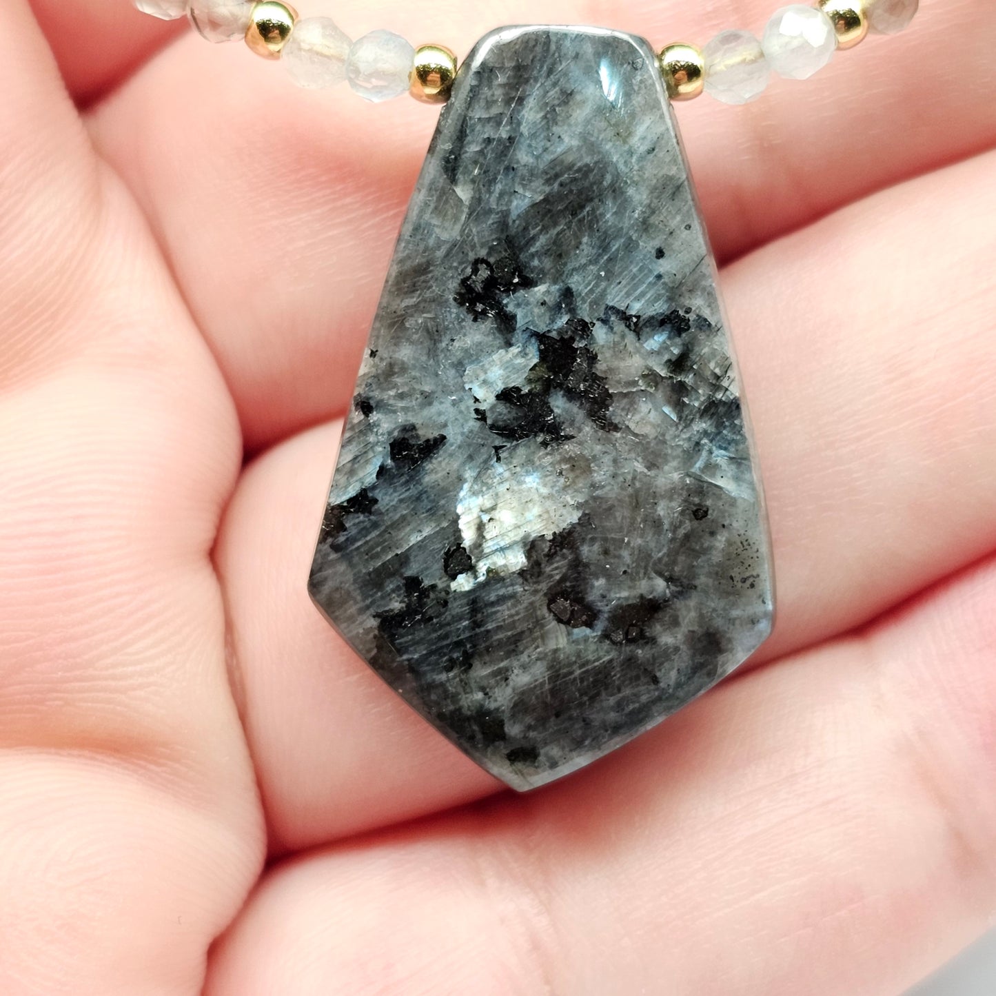 Lunar bloom is a focal Larvikite pendant necklace adorned with Smoky Quartz and Aquamarine beads.