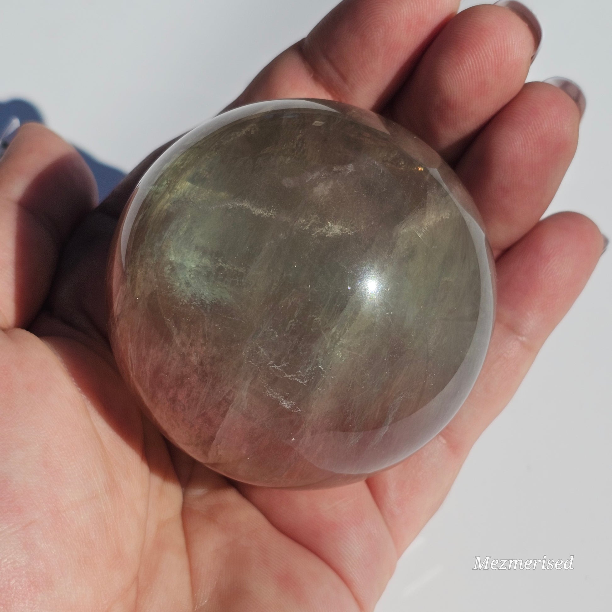 Rainbow Fluorite sphere banded with an array of colours, including a display of beautiful rainbows.