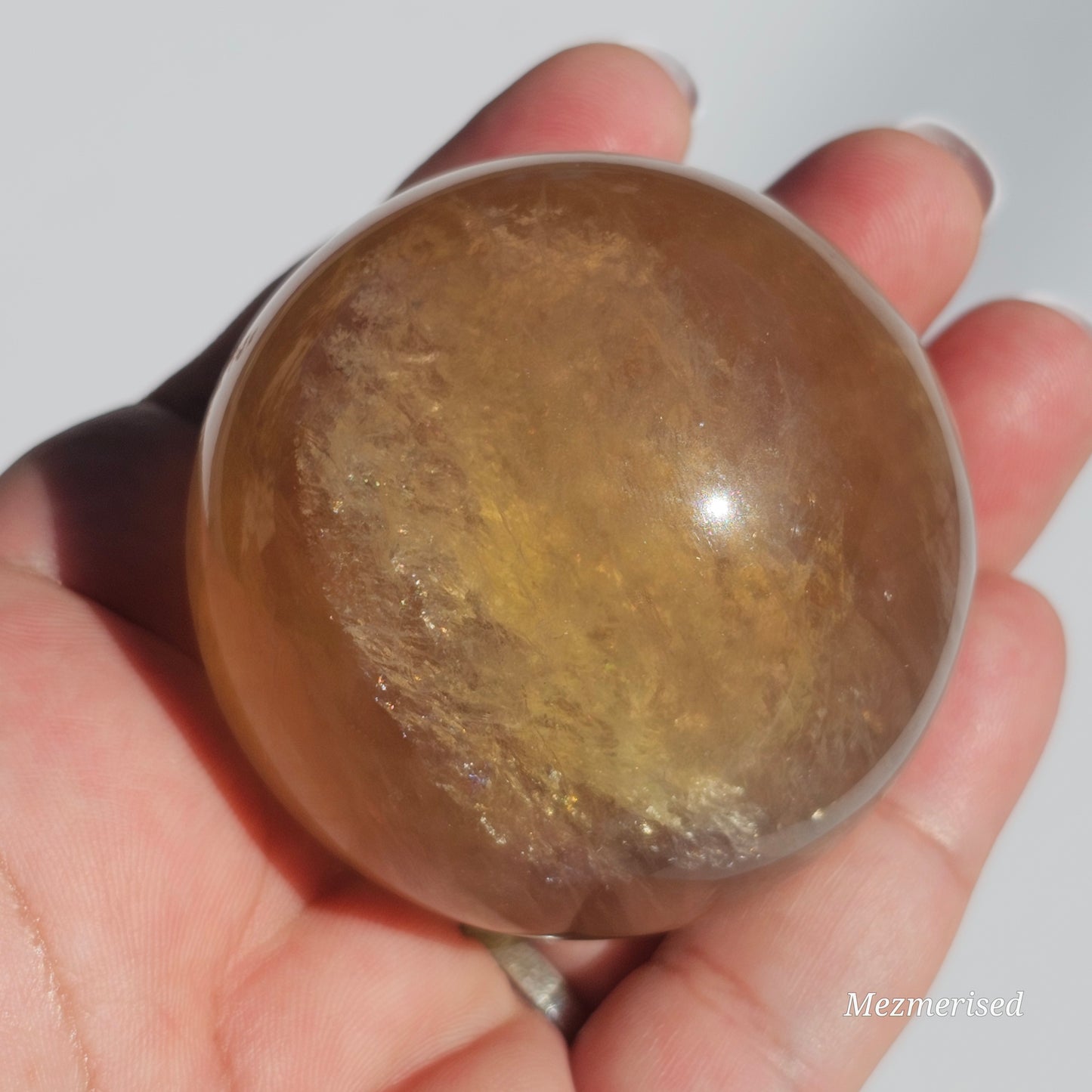 Yellow rainbow Fluorite sphere banded with an array of colours, including a display of beautiful rainbows.