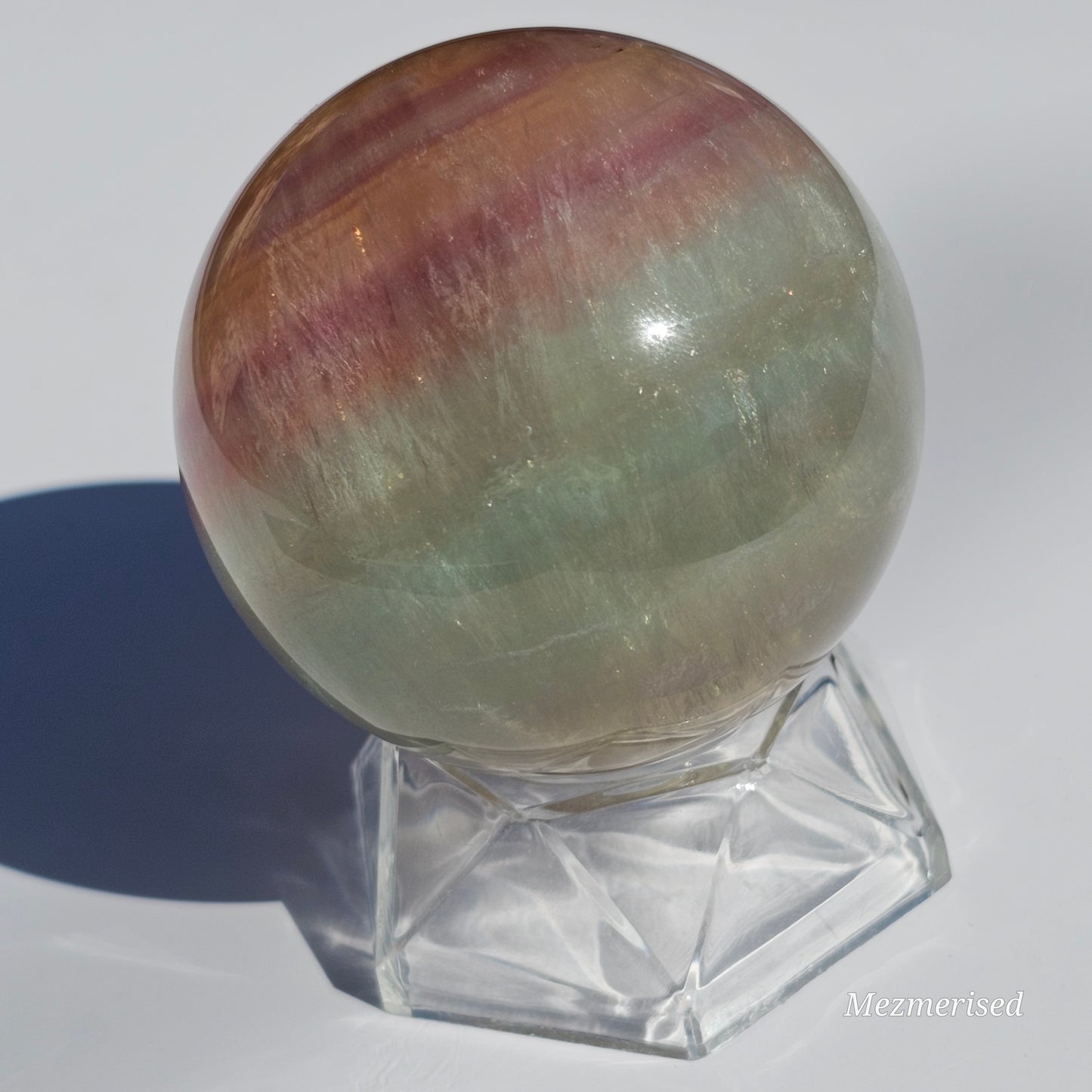 Rainbow Fluorite sphere banded with an array of colours, including a display of beautiful rainbows.